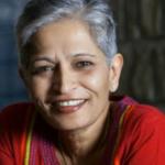 Gauri lankesh is wearing a red top with colorful embroidery, set against a blurred, dark background. The vibrancy of the attire contrasts the somber discussions on right-wing extremism in India.